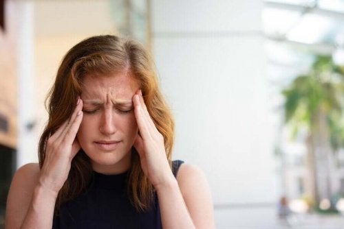 Femeie experimentând o durere de cap intensă