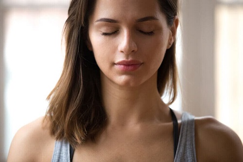 Femeie meditând pentru îmbunătățirea sănătății emoționale