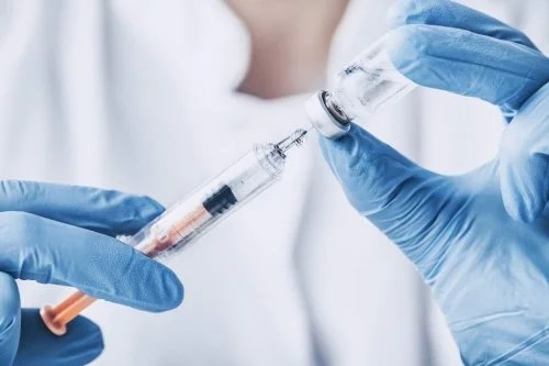 Medic care manevrează o seringă cu vaccin