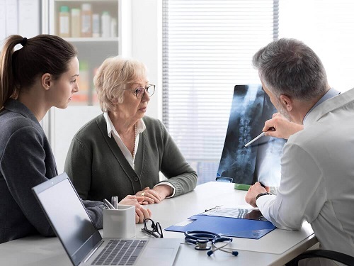Medic explicând simptomele metastazelor osoase unor pacienți