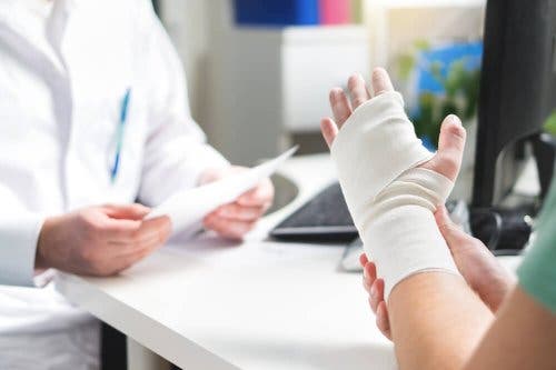 Pacient cu mâna fracturată discutând cu un medic