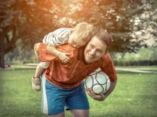 Bărbat care se joacă cu un copil cu mingea