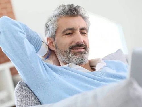 Bărbat cu părul alb care stă relaxat pe canapea