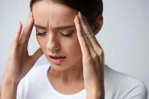 Femeie care are o durere de cap puternică
