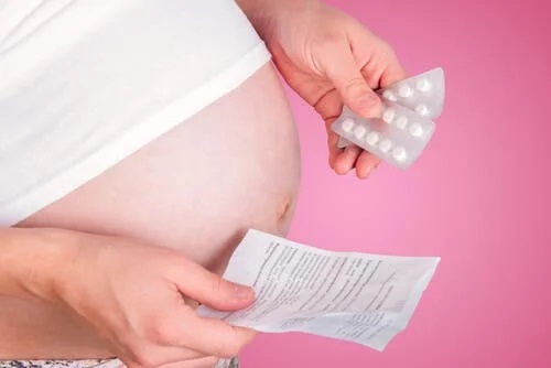 Gravidă care citește prospectul unui medicament