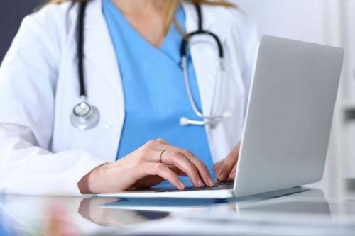 Medic tastând la laptop