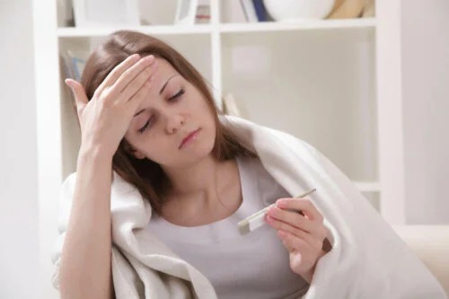 Tânără care se întreabă de ce apare febra