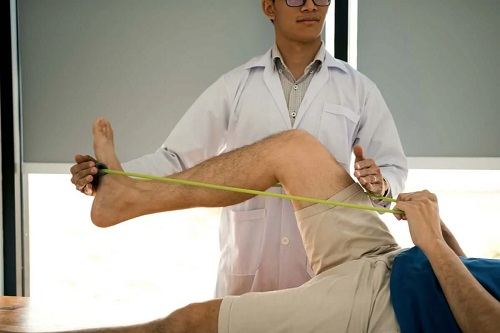 Terapeut care antrenează un pacient cu benzi elastice