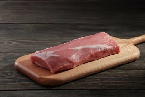 Tocător cu o bucată de carne roșie crudă