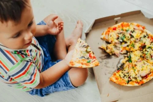 Copil care consumă pizza