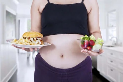 Femeie gravidă care mănâncă mult