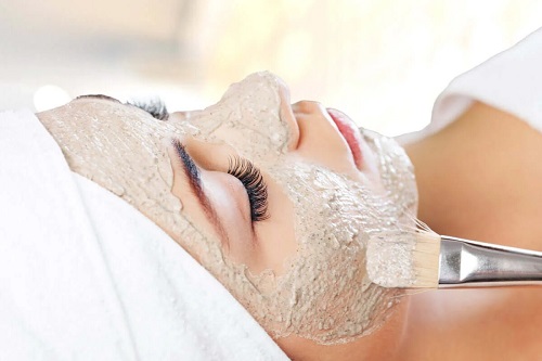 Femeie căreia i se aplică o mască facială