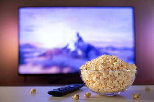Castron cu popcorn în fața televizorului