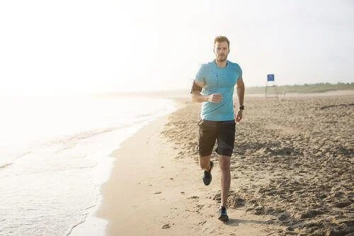Bărbat care aleargă pe plajă
