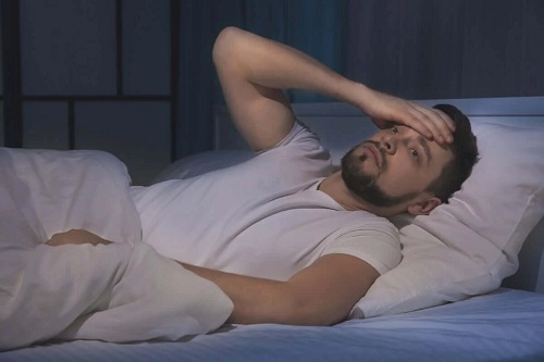 Bărbat care se confruntă cu insomnia din cauza stresului