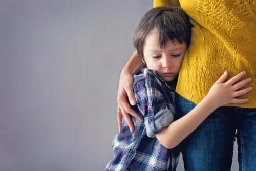 Copil speriat care își ține în brațe mama