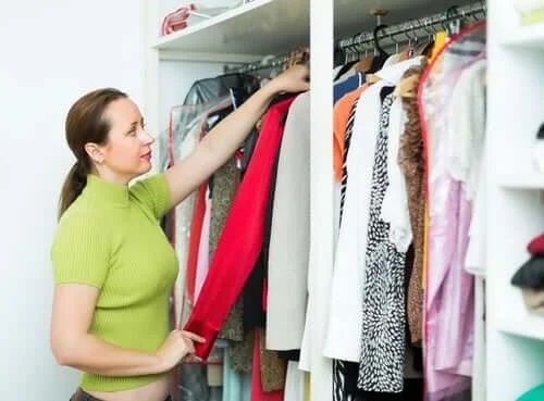 Femeie care se confruntă cu acumularea de haine în dulap