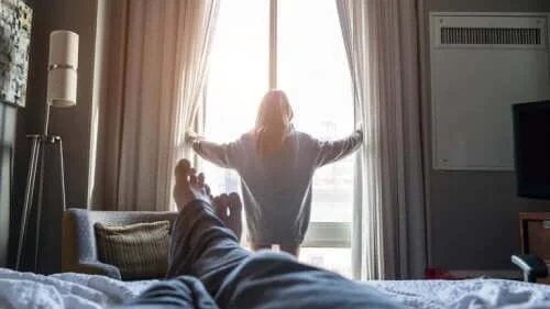 Femeie care trage perdelele