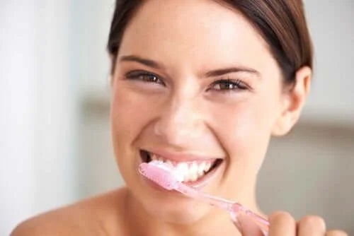 Femeie ce folosește produse naturale pentru albirea dinților