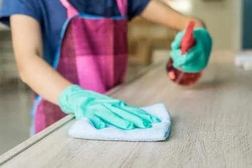 Gospodină care folosește un produs de curățare pentru mobilă natural