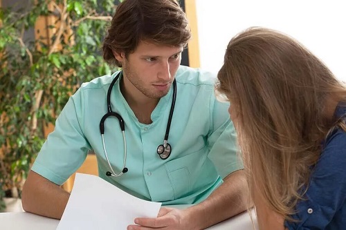 Medic ce discută cu o pacientă despre cancer