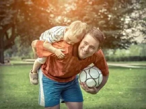Tată care cară în spate copilul