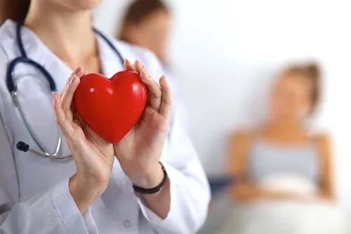 Medic care ține în mână o inimă