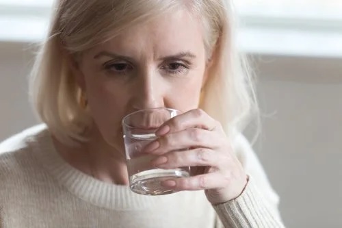Persoană care se confruntă cu căderea părului la menopauză