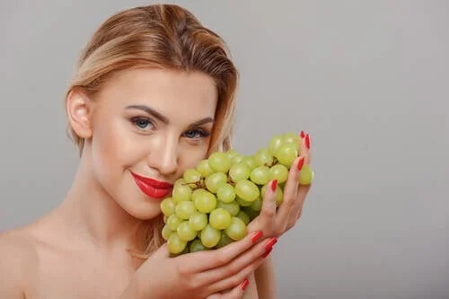 Fată care folosește struguri pentru întinerirea pielii