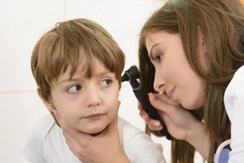 Medic care examinează infecțiile urechii la copii