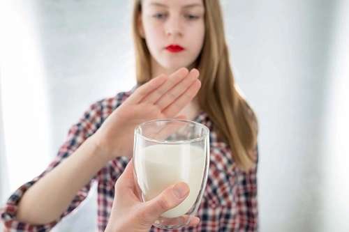 Fată care refuză un pahar de lapte