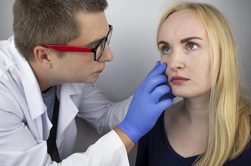Medic care tratează o femeie cu neuromielită optică