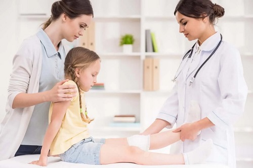 Medic care aplică un tratament pentru genu varum