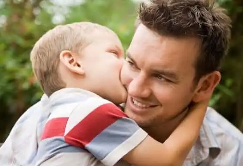 Copil care își sărută tatăl