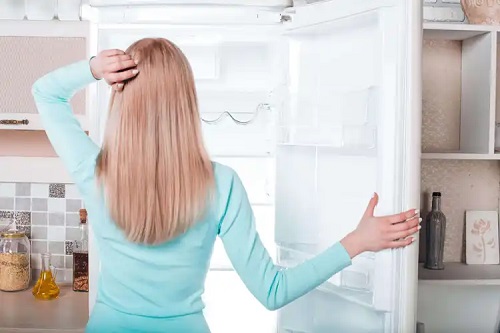 Femeie cu frigiderul gol