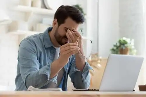 Bărbat obosit stând la PC