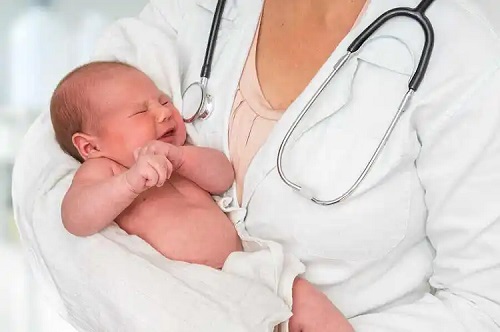 Medic care ține în brațe un bebeluș