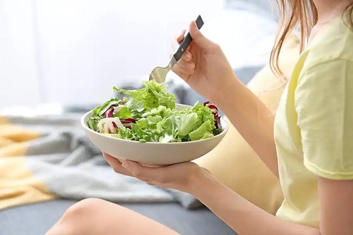 Persoană care consumă salată