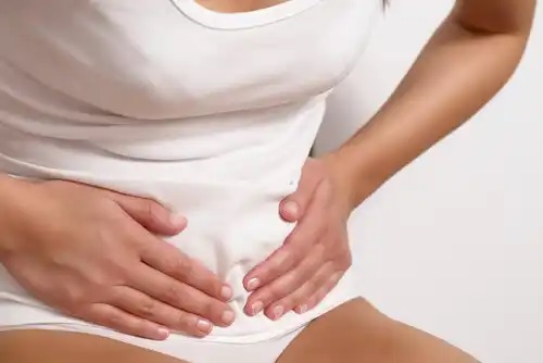 Tânără afectată de durerea intermenstruală