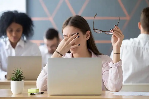 Fată cu ochii obosiți din cauza calculatorului