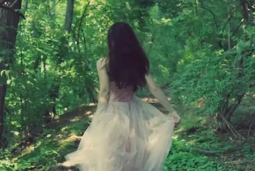 Fată care merge prin pădure