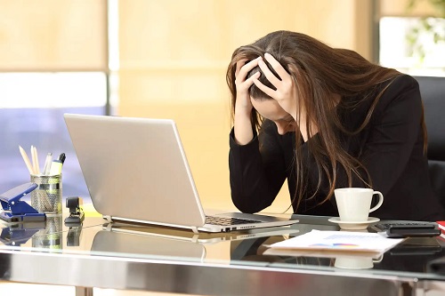 Femeie care nu controlează anxietatea la serviciu