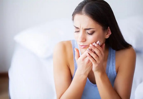 Femeie afectată de tulburările articulare temporomandibulare