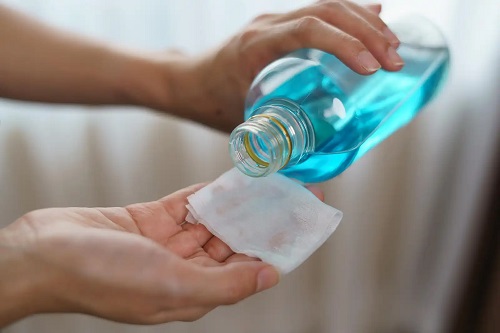 Persoană care folosește alcoolul pentru curățenie