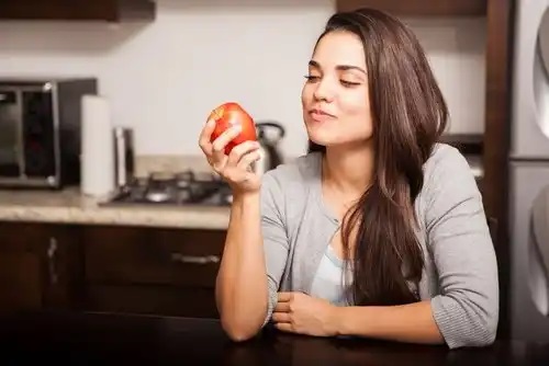 Femeie care știe că mărul poate preveni gazele și indigestia
