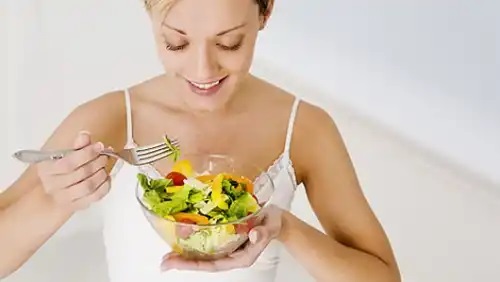 Femeie care consumă o salată