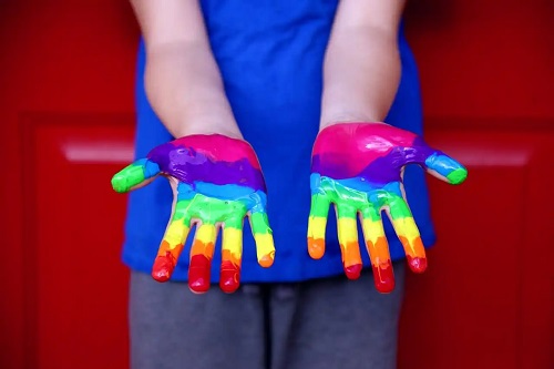 Persoană cu mâinile colorate cu vopsea
