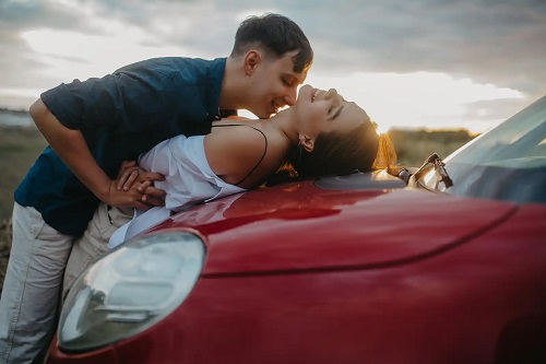 Cuplu care se sărută pe mașină