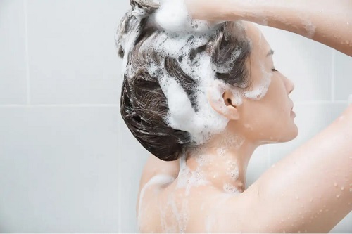 Femeie care se spală pe cap