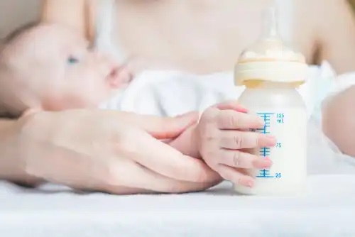 Bebeluș cu biberon cu lapte